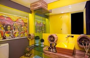 O lavabo super colorido conta com bancada, cuba e acabamentos feitos de madeira de demolio. A cor amarela d mais alegria ao ambiente